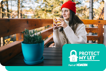 A woman with a red hat sat with a cup of coffee looking into the distance