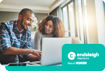 A man and a woman looking at a laptop smiling